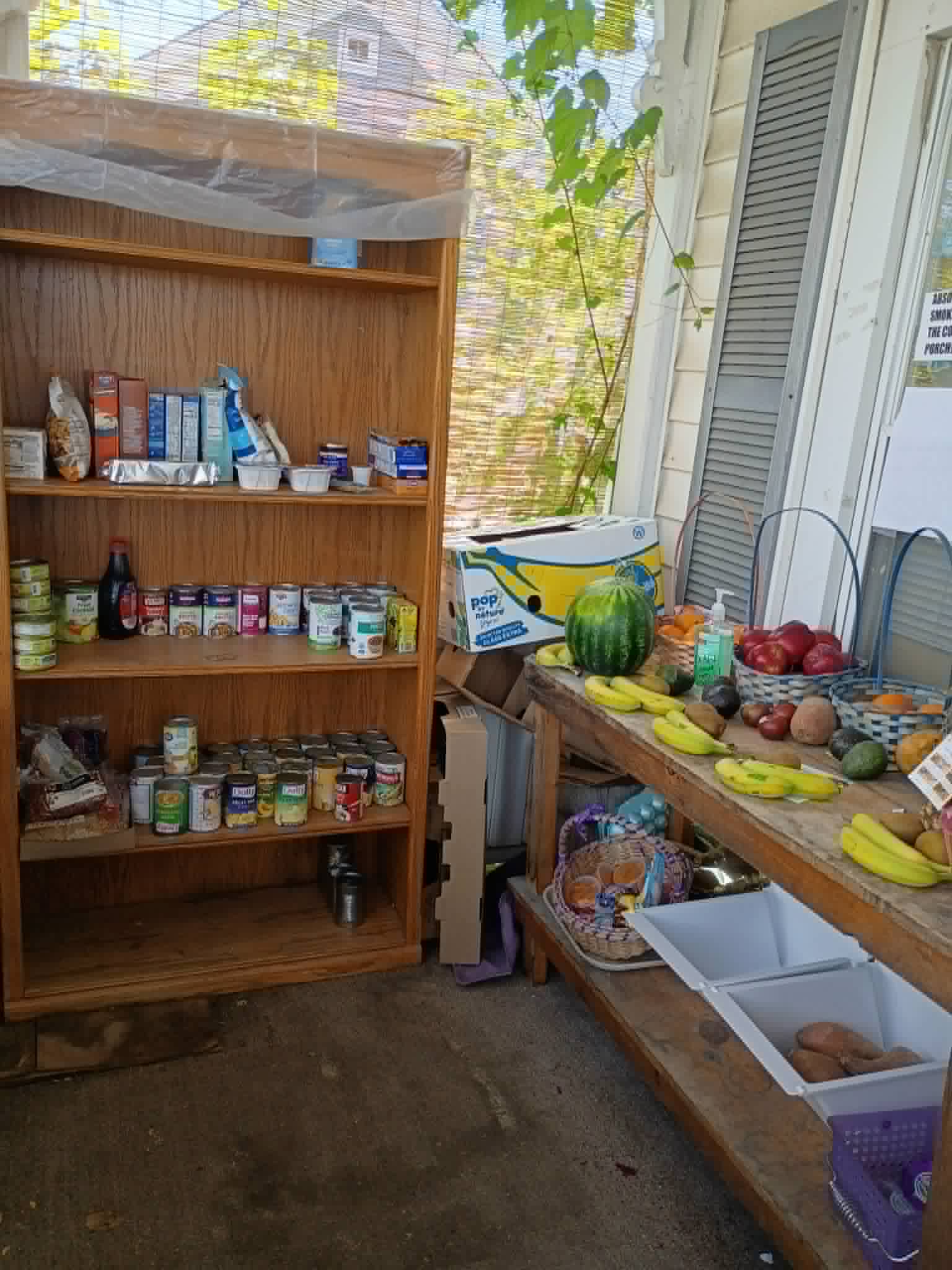 The Community Porch in Hoosick Falls NY with stocked shelves and a table of fresh fruit and vegetables