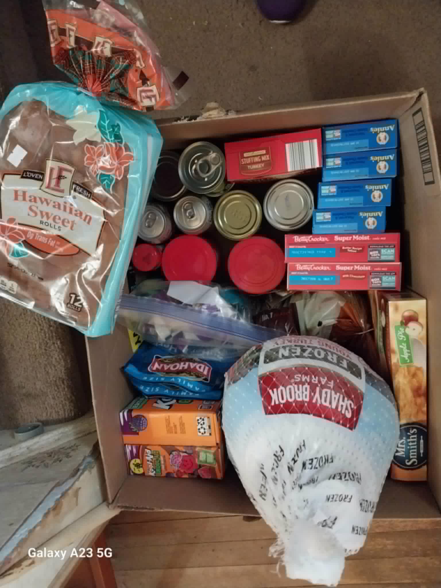 A full Thanksgiving meal box with a turkey, stuffing, and canned goods from the Community Porch in Hoosick Falls NY