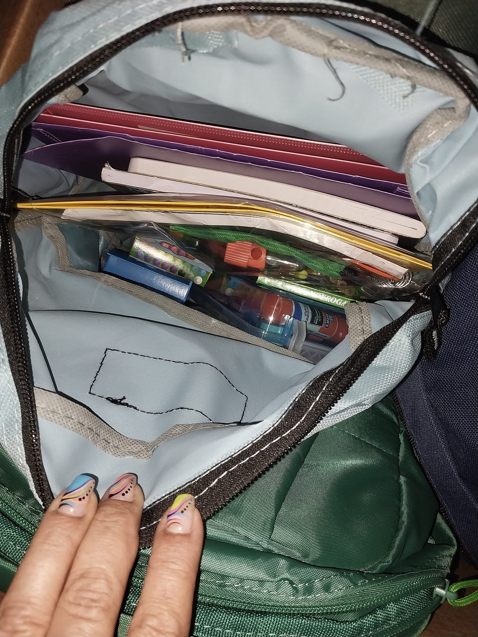 An open backpack filled with folders, notebooks, and supplies for the Community Porch backpack program in Hoosick Falls NY