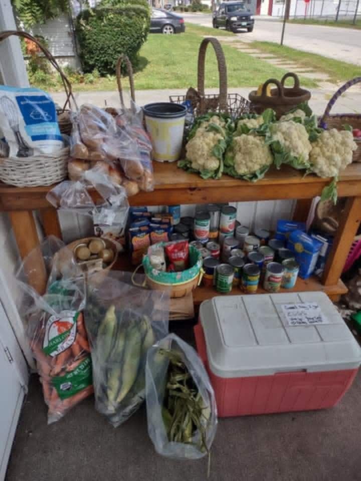 Fresh cauliflower, bread, carrots, and produce laid out on the Community Porch table in Hoosick Falls NY