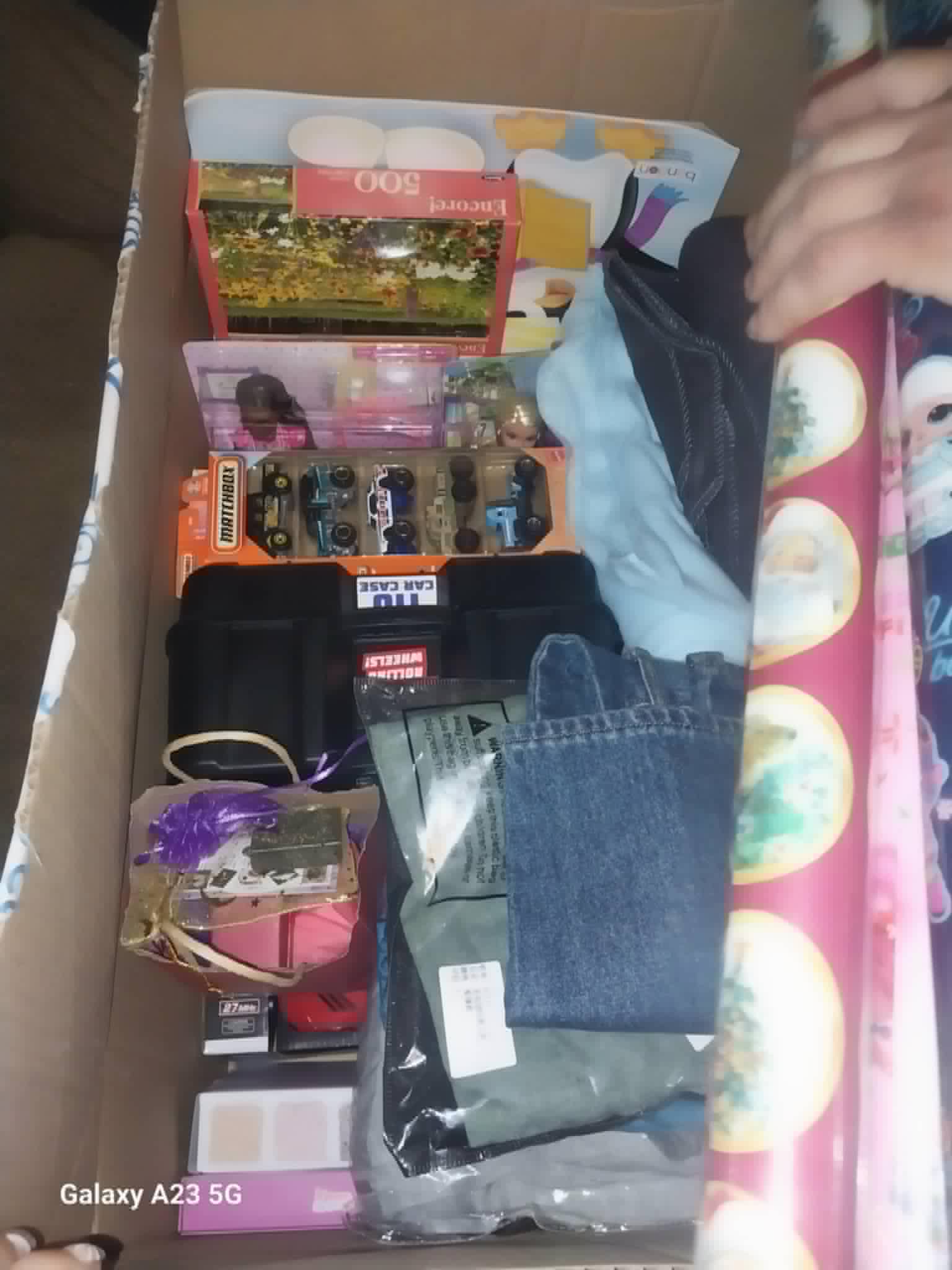 A box of Christmas gifts including puzzles, toy cars, and dolls for the Community Porch in Hoosick Falls NY