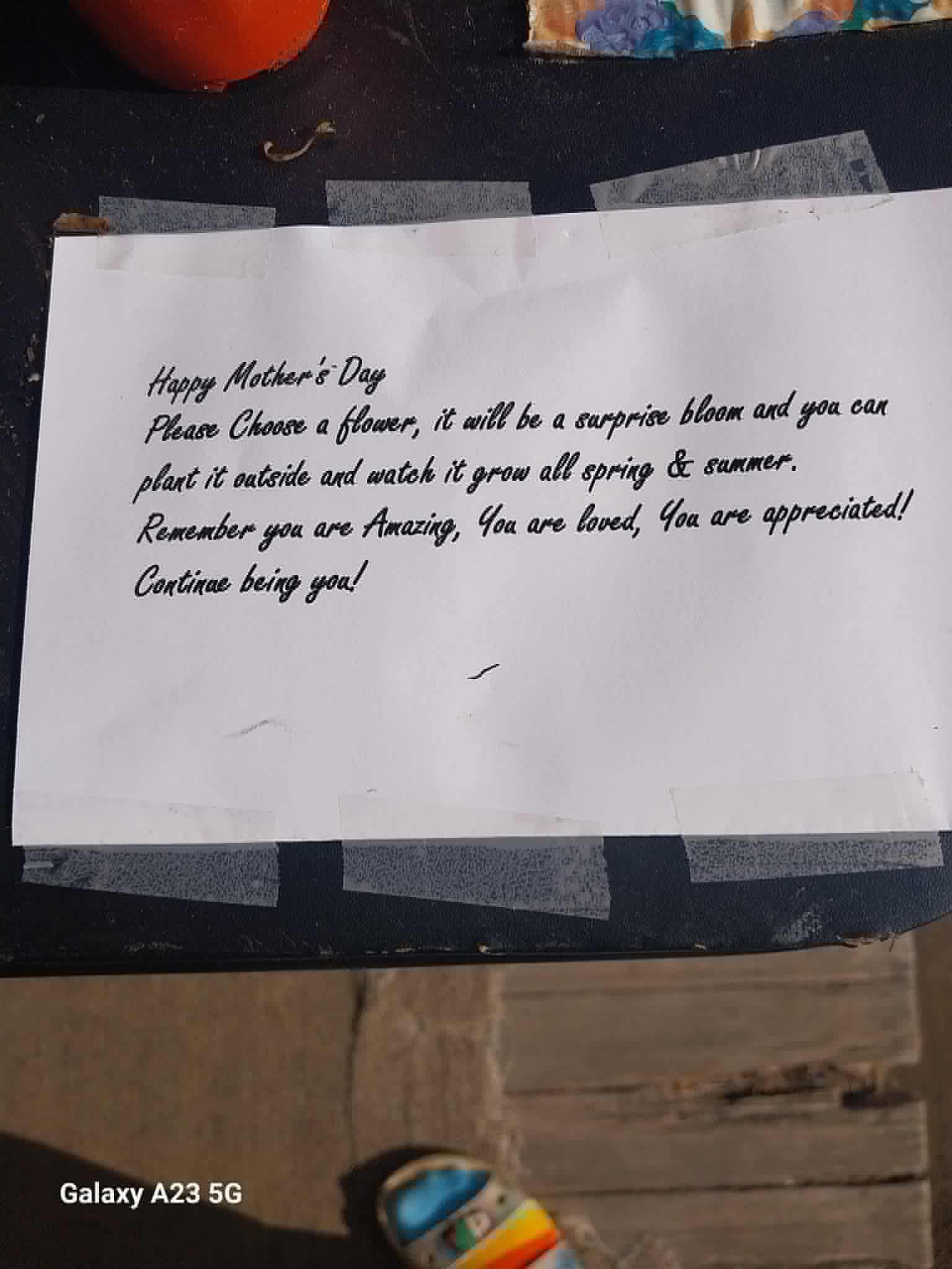 A Mother's Day note on the Community Porch in Hoosick Falls NY inviting moms to choose a flower to plant and watch grow