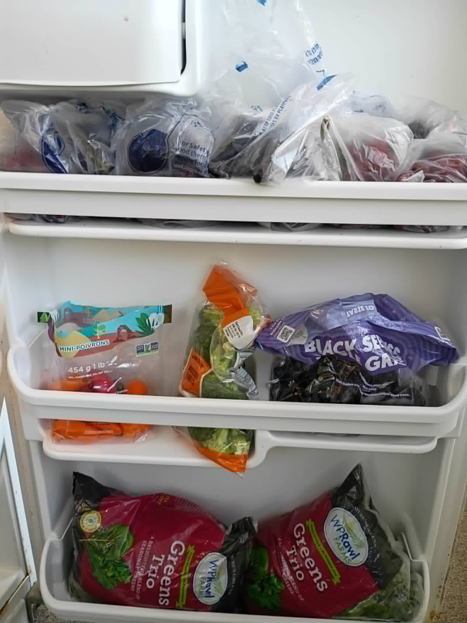 A refrigerator stocked with bagged greens, broccoli, grapes, and carrots at the Community Porch in Hoosick Falls NY
