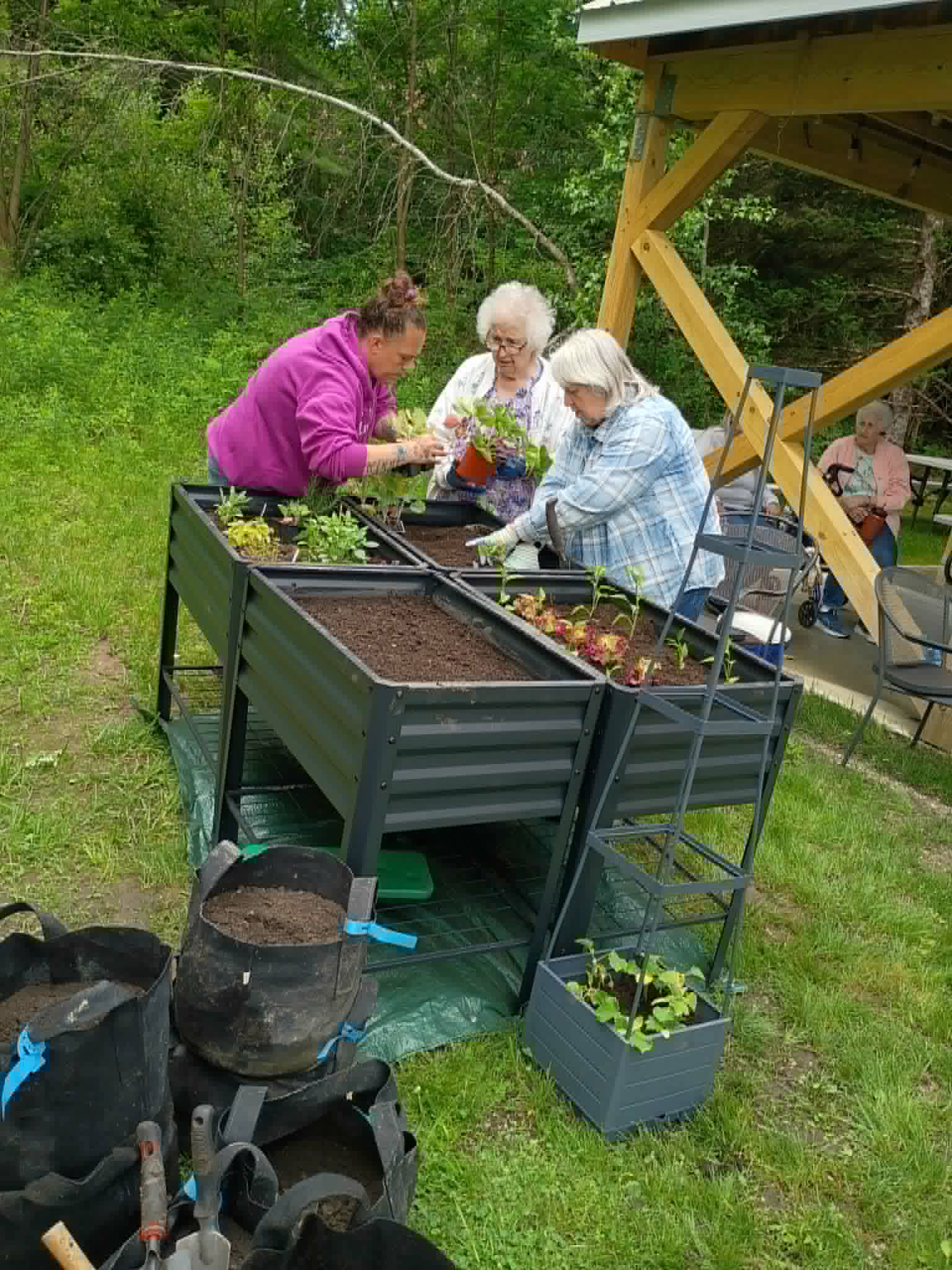 Volunteers and senior center residents planting elevated raised garden beds together for the Community Porch Grow and Share program near Hoosick Falls NY